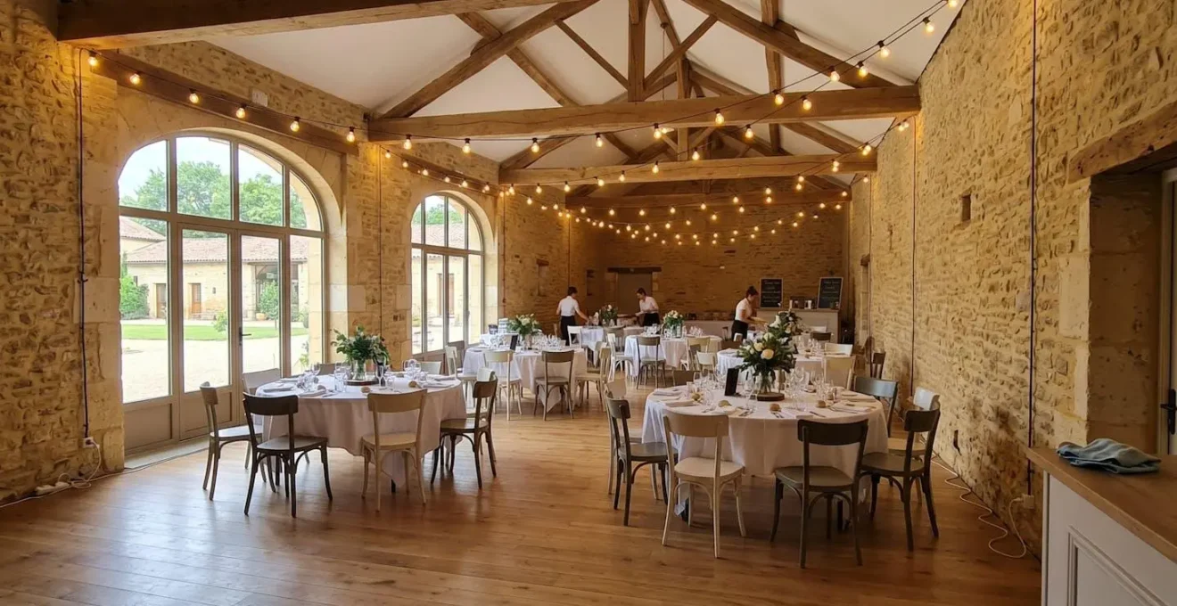 Salle de réception contemporaine avec tables rondes disposées harmonieusement sous un éclairage ambiant chaud créant une atmosphère équilibrée